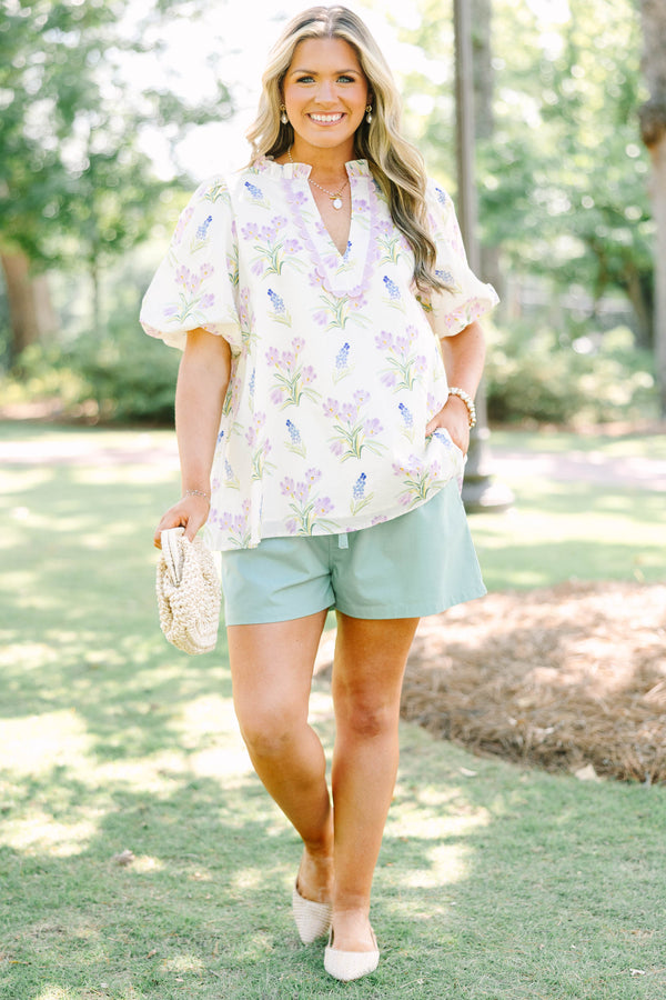 Plus Size cream floral top with puff sleeves, ric rac V-neckline, and light green shorts.