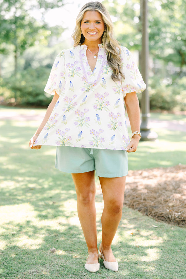 Plus Size cream floral top with puff sleeves, ric rac V-neckline, and light green shorts.