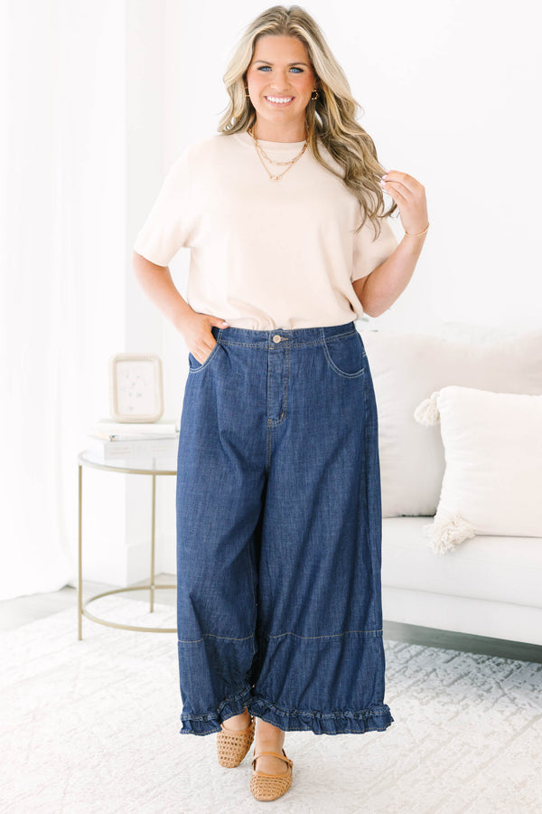 Plus size dark denim wide leg pants with a flowy fit and feminine ruffle hem detail.