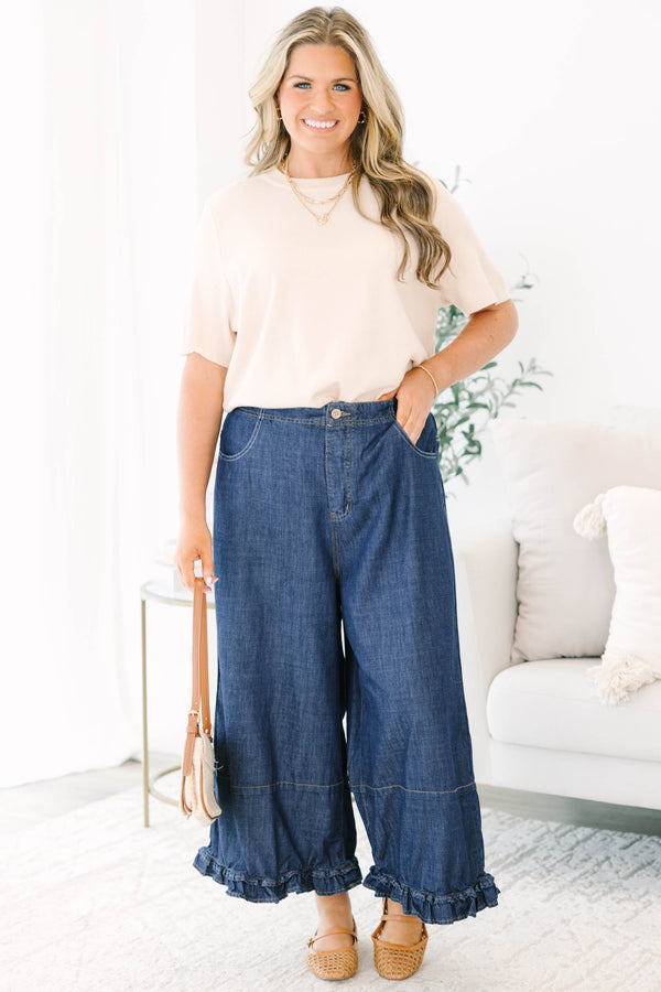 Plus size dark denim wide leg pants with a flowy fit and feminine ruffle hem detail.