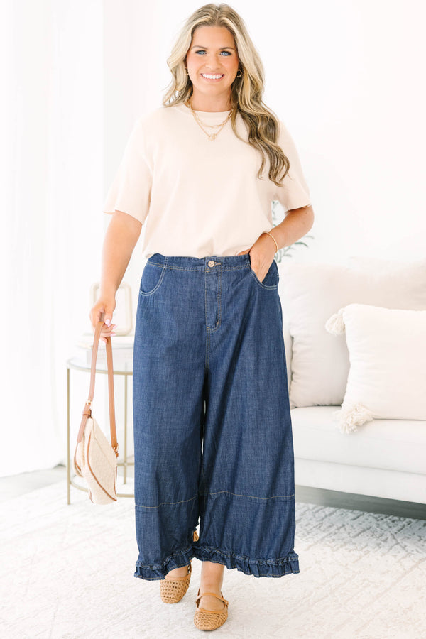 Plus size dark denim wide leg pants with a flowy fit and feminine ruffle hem detail.