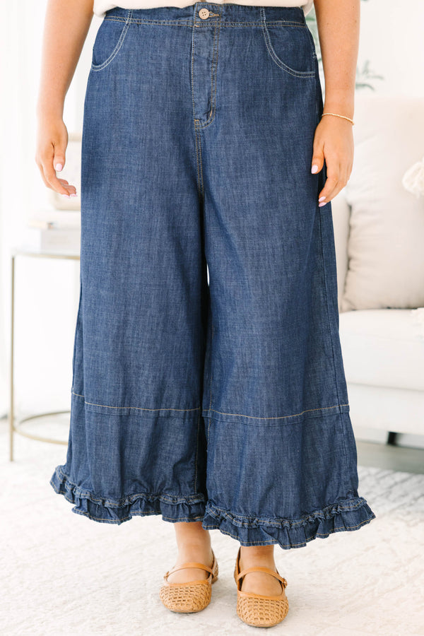Plus size dark denim wide leg pants with a flowy fit and feminine ruffle hem detail.