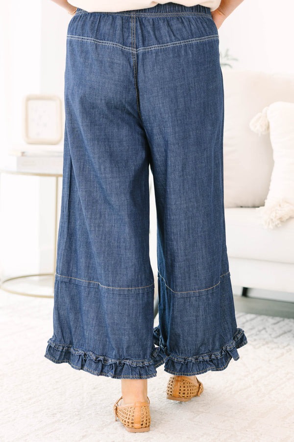 Plus size dark denim wide leg pants with a flowy fit and feminine ruffle hem detail.
