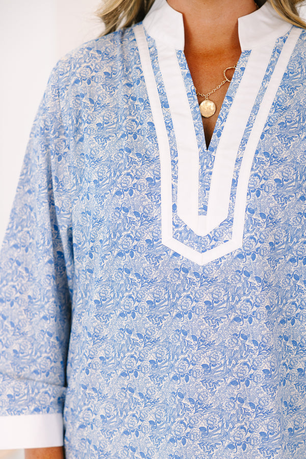 Plus Size blue and white floral tunic dress with a white-trimmed V-neckline and long sleeves.