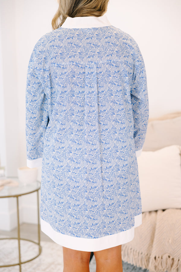 Plus Size blue and white floral tunic dress with a white-trimmed V-neckline and long sleeves.