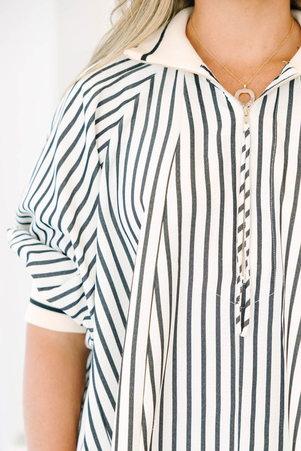 Plus size black and white striped top with a flowy fit, quarter-zip neckline, and ribbed cuffs.