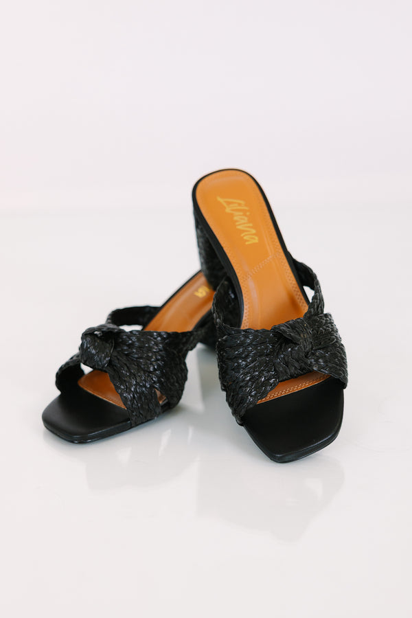 Black block heels with a woven knotted strap and a square open toe.