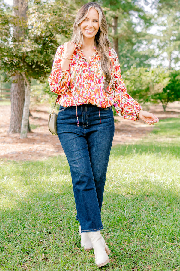 Chic Soul plus size clothing, ivory long bubble sleeve top with rust, orange, and pink abstract pattern and two ties at the collar