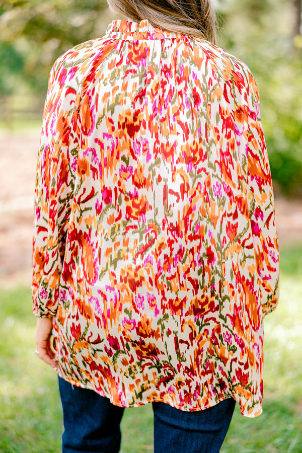 Chic Soul plus size clothing, ivory long bubble sleeve top with rust, orange, and pink abstract pattern and two ties at the collar