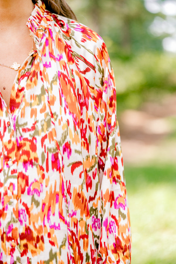 Chic Soul plus size clothing, ivory long bubble sleeve top with rust, orange, and pink abstract pattern and two ties at the collar