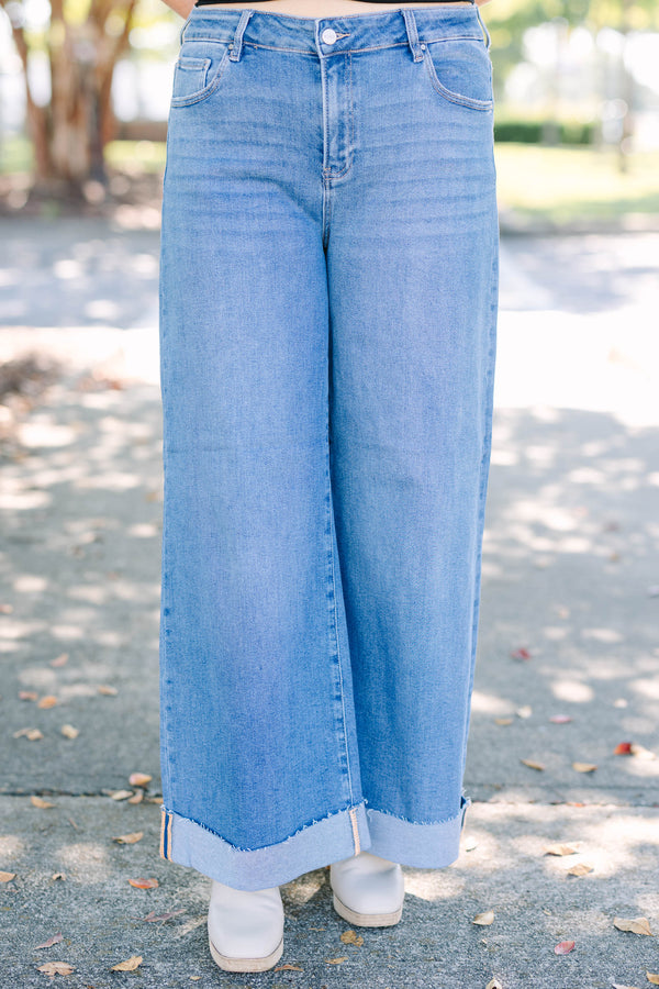 Plus Size medium wash wide leg jeans with a high waist and raw-edge cuffed hems.