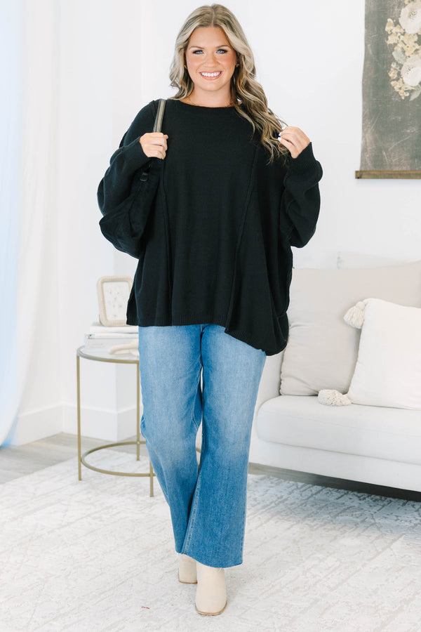 Plus Size black oversized knit sweater with a crew neckline, drop shoulders, and seam detailing.