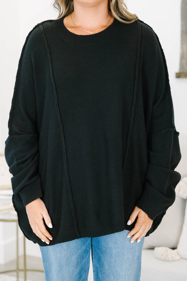 Plus Size black oversized knit sweater with a crew neckline, drop shoulders, and seam detailing.