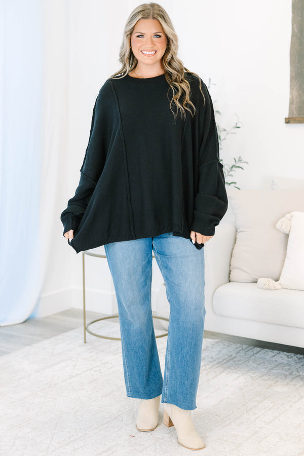 Plus Size black oversized knit sweater with a crew neckline, drop shoulders, and seam detailing.