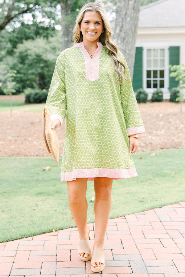 Plus size olive green geometric print tunic dress with pink embroidered trim and side pockets.