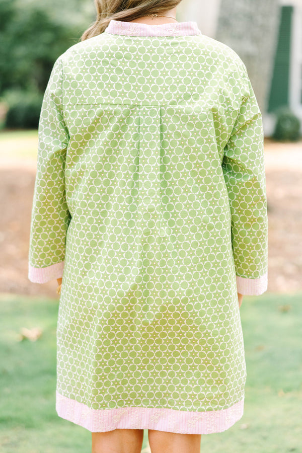 Plus size olive green geometric print tunic dress with pink embroidered trim and side pockets.
