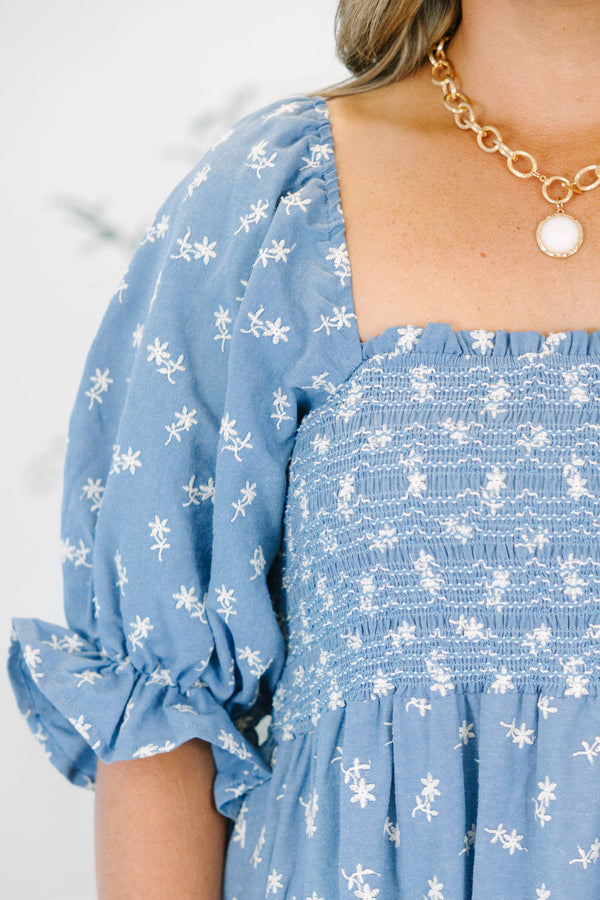 Plus size blue floral midi dress with a smocked bodice, puff sleeves, and a flowy tiered skirt.