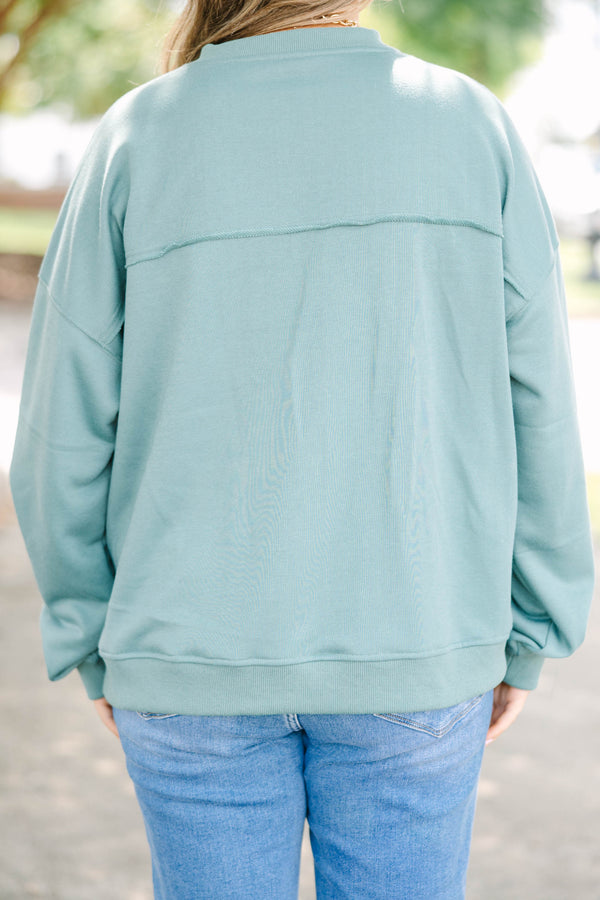 Plus size green tunic sweatshirt with a split v-neck, raw seam details, and a relaxed fit.