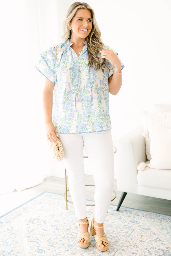 Plus size blue floral ruffle sleeve top with v neckline that ties with tassels across the neck