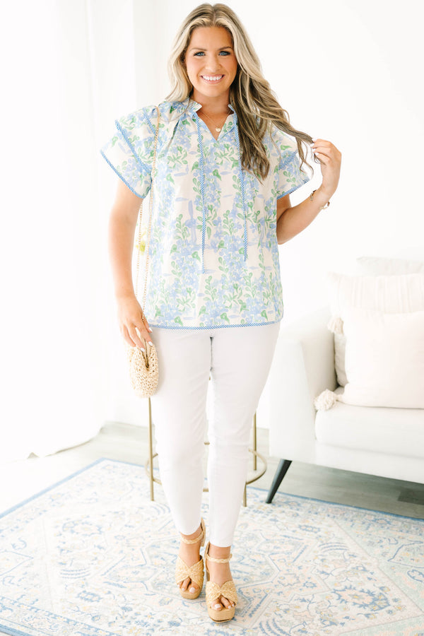Plus size blue floral ruffle sleeve top with v neckline that ties with tassels across the neck