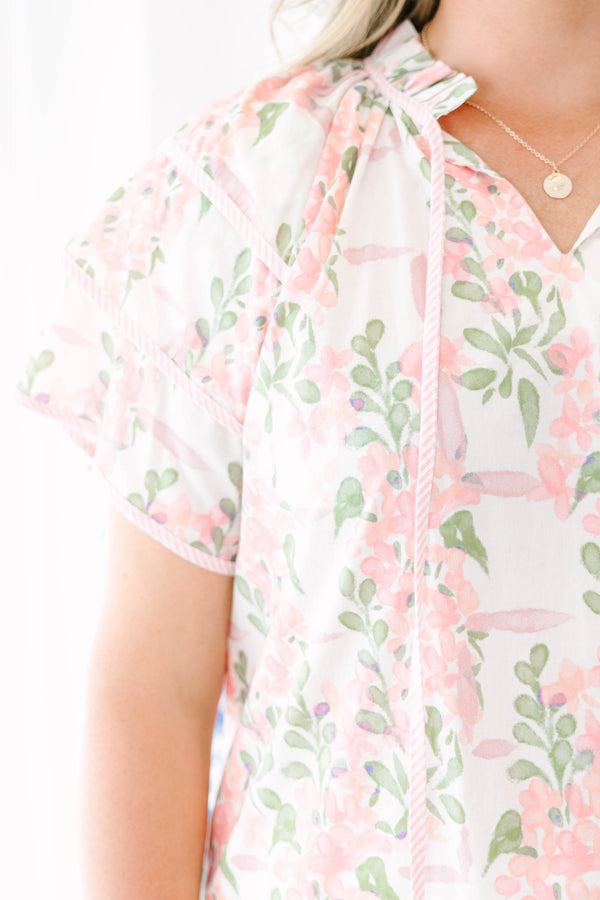 Plus Size pink and green floral print top with ruffled short sleeves and a tie-neckline.