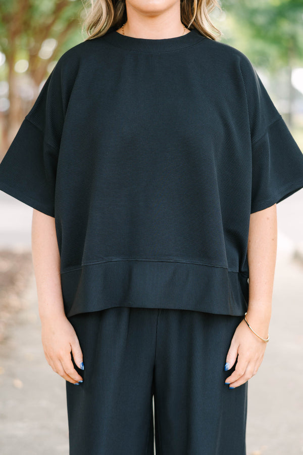 Plus size black ribbed knit lounge set with a boxy short sleeve top and matching pants.