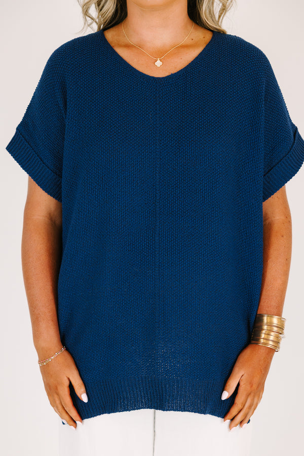 Plus Size light navy short sleeve knit sweater with a center seam and white pants.