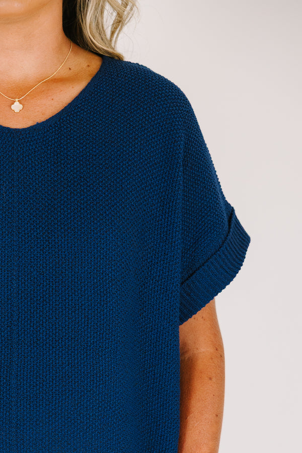 Plus Size light navy short sleeve knit sweater with a center seam and white pants.