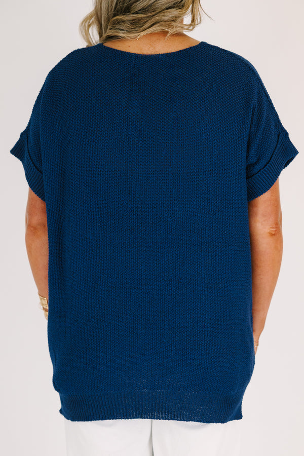 Plus Size light navy short sleeve knit sweater with a center seam and white pants.