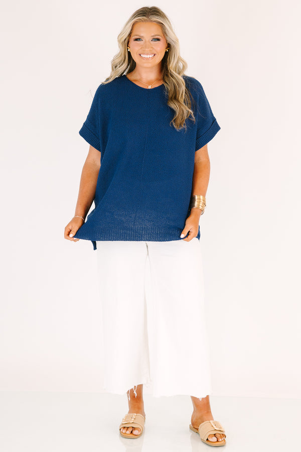 Plus Size light navy short sleeve knit sweater with a center seam and white pants.