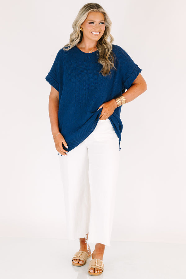 Plus Size light navy short sleeve knit sweater with a center seam and white pants.