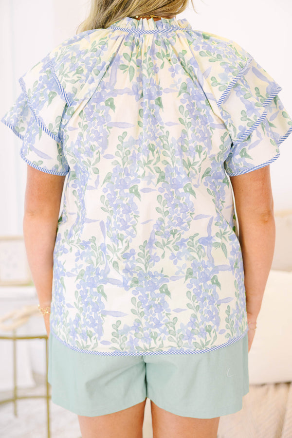 Plus size blue floral ruffle sleeve top with v neckline that ties with tassels across the neck