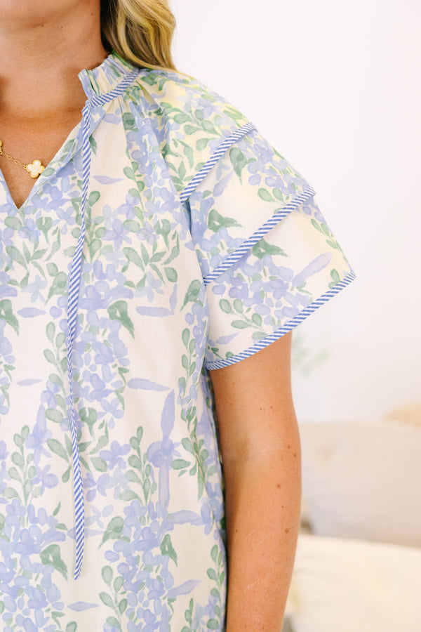 Plus size blue floral ruffle sleeve top with v neckline that ties with tassels across the neck