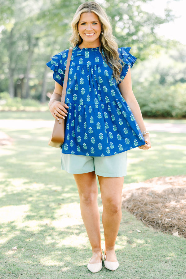 Plus Size navy blue tiered top with a green floral pattern, ruffle sleeves, and a high neckline.