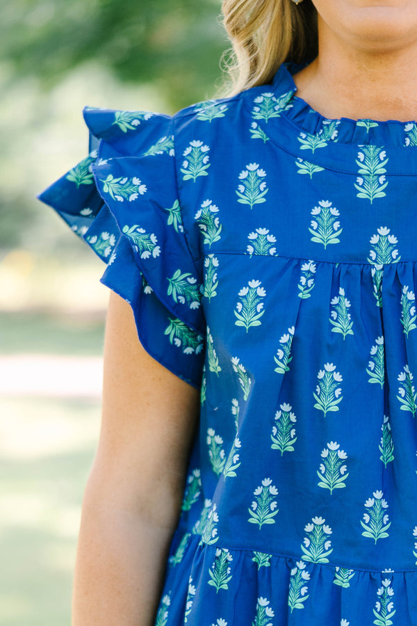 Plus Size navy blue tiered top with a green floral pattern, ruffle sleeves, and a high neckline.