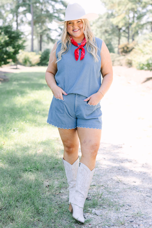 Plus Size denim shorts with white scalloped trim on the pockets and hem, paired with white boots.
