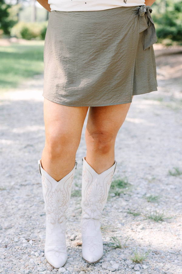 Plus Size olive green wrap-style skort with a side tie, paired with white embroidered cowboy boots.