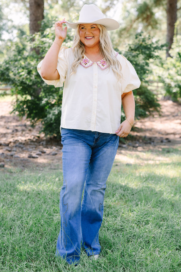 Plus Size medium wash flare jeans with studded embroidery along the outer side seams.