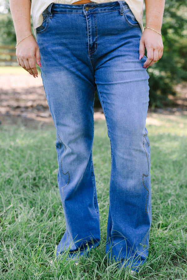 Plus Size medium wash flare jeans with studded embroidery along the outer side seams.
