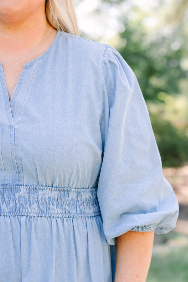 Plus Size blue denim tiered maxi dress with puff sleeves, a v-neckline, and a brown concho belt.