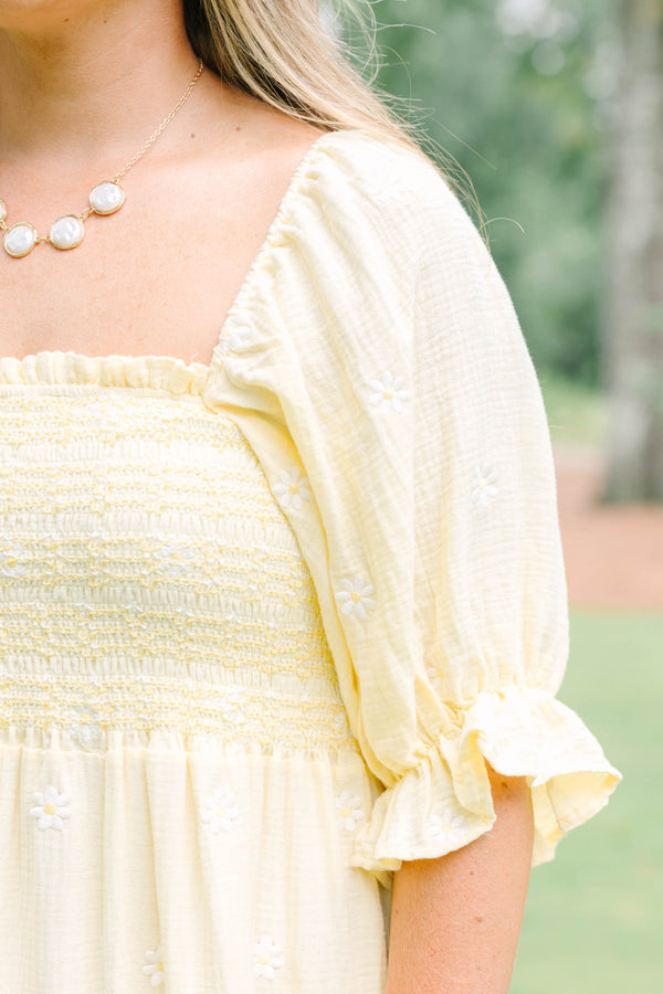 Plus Size yellow midi dress with smocked bodice, puff sleeves, and white floral embroidery.