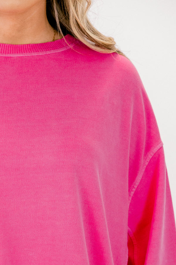 Close-up of a bright pink sweater on a white background