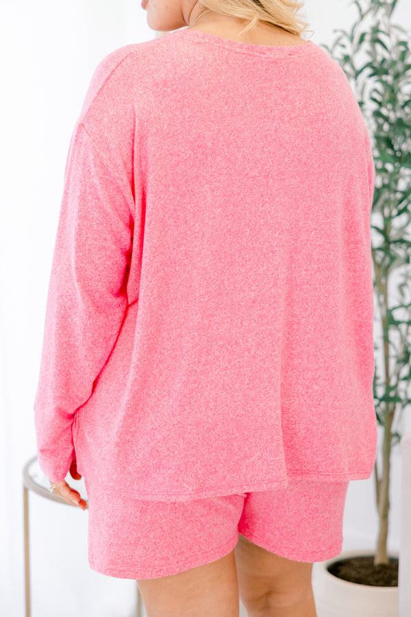 Person wearing a pink long-sleeve top and shorts set with a blurred background