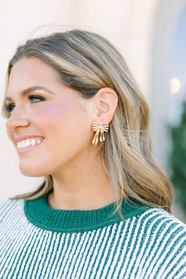 Plus Size gold bow-shaped stud earrings with a ribbed texture and dangling ribbon tails.
