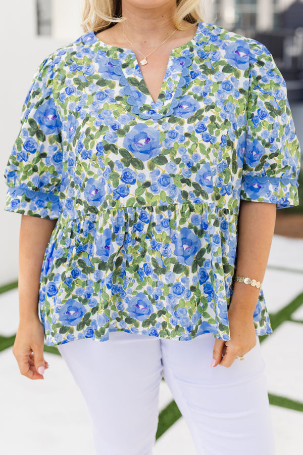 Chic Soul plus size clothing, blue short sleeve top with a green and blue floral pattern as well as scalloped stitching details along the bottom of the sleeves and along the v-neckline 