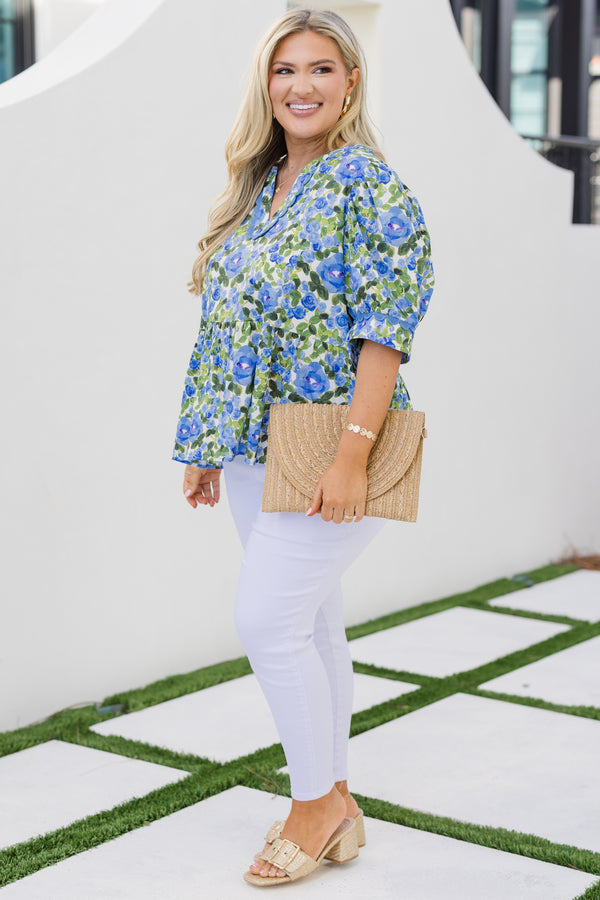 Chic Soul plus size clothing, blue short sleeve top with a green and blue floral pattern as well as scalloped stitching details along the bottom of the sleeves and along the v-neckline 
