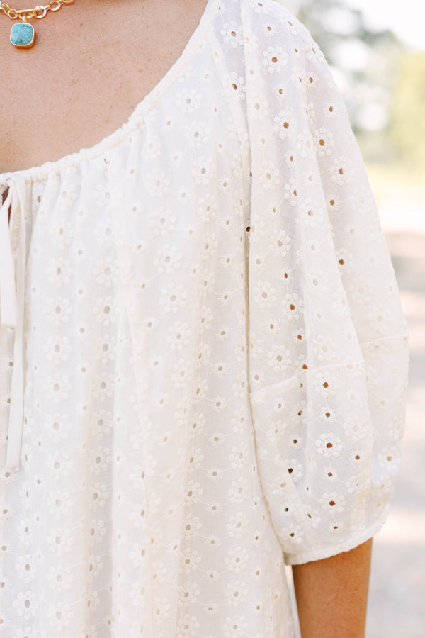 Plus Size ivory cotton eyelet dress with a scoop neckline, tie detail, and short puff sleeves.