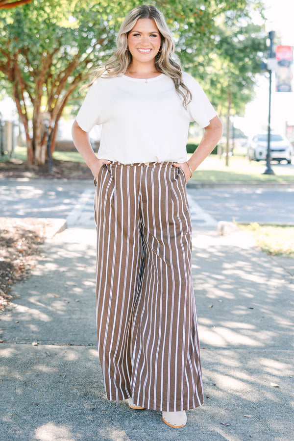 Plus size brown and white vertical stripe wide-leg pants in a flowy rayon fabric.