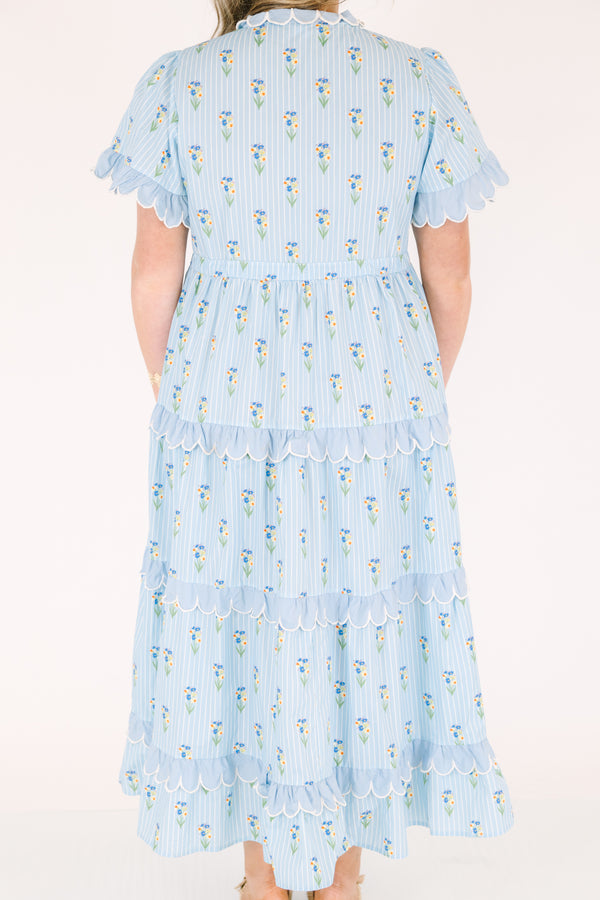 Chic Soul plus size clothing, blue maxi  dress with a floral pattern and scalloped ruffle detailing on the ends of the sleeves going down the v-neckline and on each tier of the dress as well as a bow that ties under the chest area 