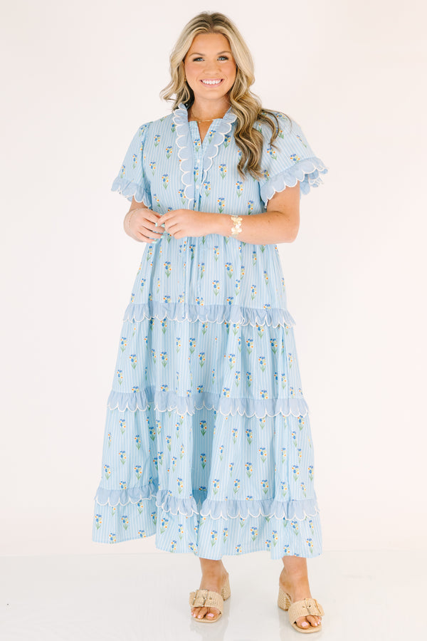 Chic Soul plus size clothing, blue maxi  dress with a floral pattern and scalloped ruffle detailing on the ends of the sleeves going down the v-neckline and on each tier of the dress as well as a bow that ties under the chest area 